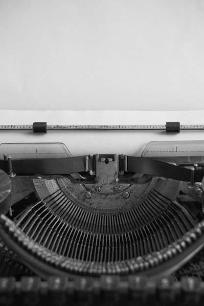 Czarno-biały obraz zabytkowej maszyny do pisania i czystego papieru