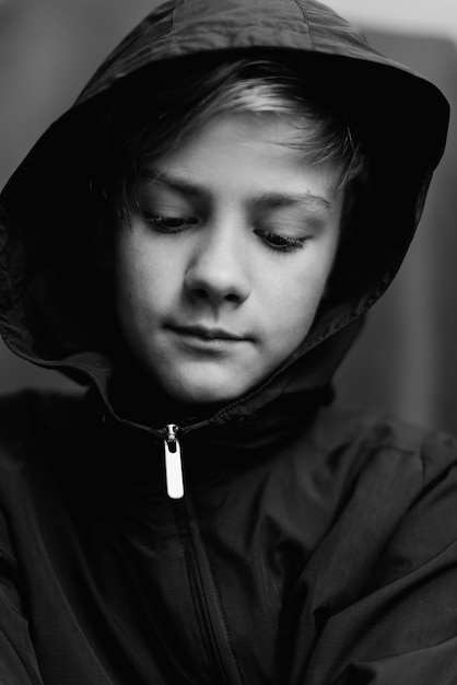 Czarno-biały portret nastoletniego chłopca na ciemnym tle Niski klucz z bliska strzał młodego chłopca nastolatka Fotografia czarno-biała Selektywna ostrość