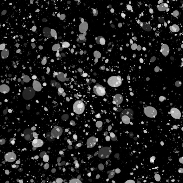 Czarno-biały śnieg spada na czarnym tle