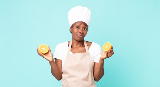 Czarny african american kobieta dorosły kucharz. koncepcja soku pomarańczowego
