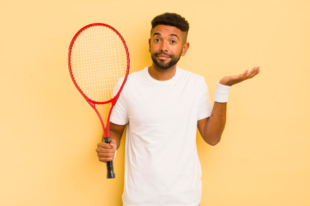 Czarny afro mężczyzna czuje się zakłopotany, zdezorientowany i wątpi w koncepcję tenisa