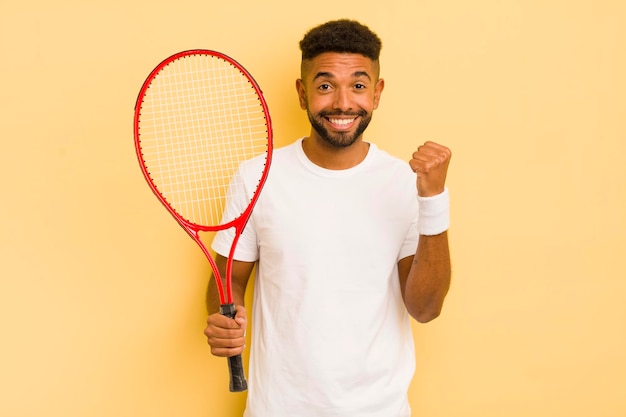 Czarny afro mężczyzna czuje się zszokowany, śmiejąc się i świętując sukces koncepcji tenisa