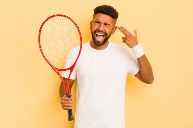 Czarny afro mężczyzna wyglądający na niezadowolonego i zestresowanego gestu samobójczego, dzięki czemu koncepcja tenisa znak pistoletu