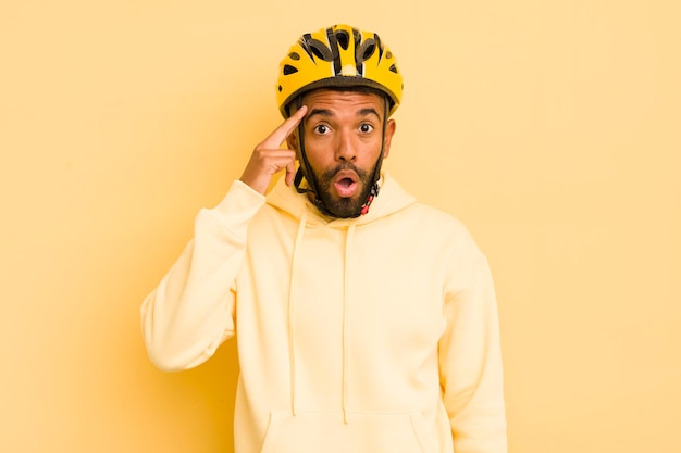 Czarny afro mężczyzna wyglądający na zaskoczonego, realizującego nowy pomysł na myśl lub koncepcję roweru koncepcyjnego