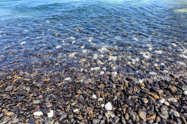 Czarny kamień naturalny w tropikalnym morzu na linii brzegowej