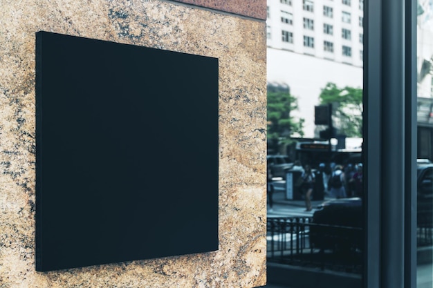 Czarny kwadratowy znak z pustą przestrzenią dla logo na marmurowej ścianie nowoczesnego centrum biznesowego