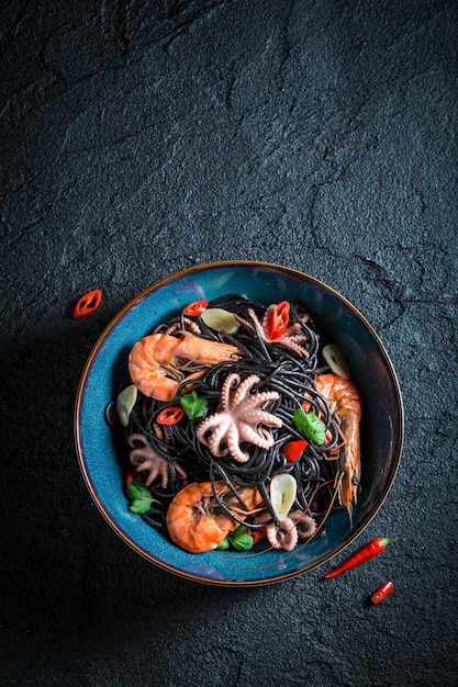 Czarny makaron ze świeżych owoców morza z krewetek tygrysich ośmiornic