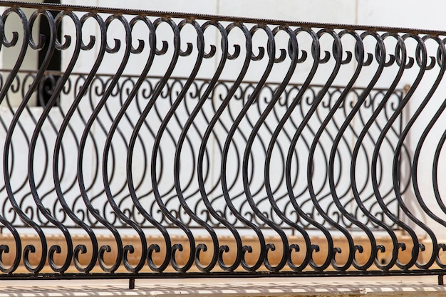 Czarny metalowy płot zbliżenie Piękne ozdobne żeliwne kute ogrodzenie z artystycznym kuciem Metalowa poręcz