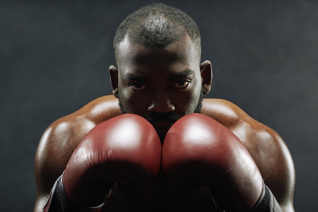 Czarny muskularny bokser z czerwonymi rękawiczkami.