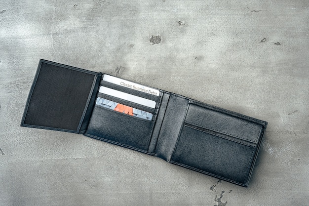 Czarny nowy skórzany portfel na szarym betonie