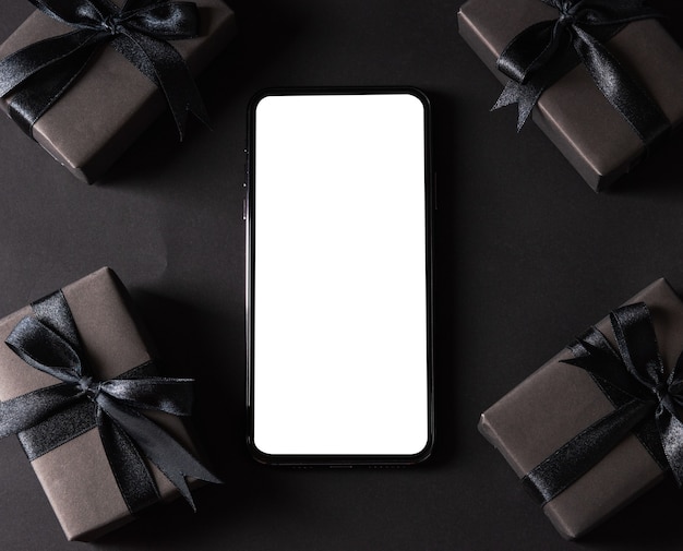 Czarny Piątek, Pudełko Owinięte Czarnym Papierem I Kokardka Wokół Pustego Ekranu Smartfona