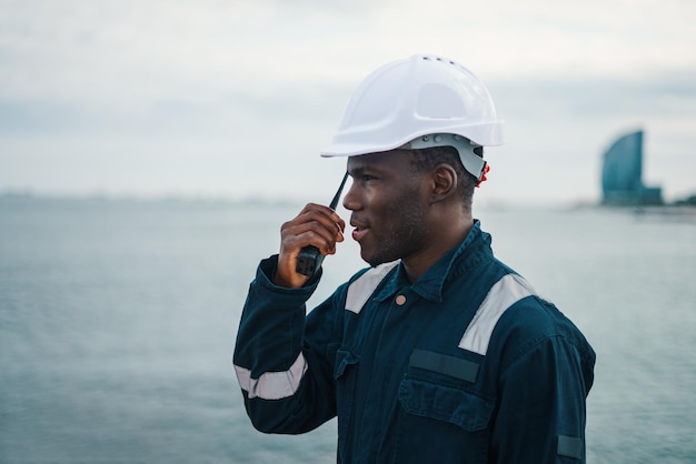 Zdjęcie czarny pracownik morski mówiący przez krótkofalówkę