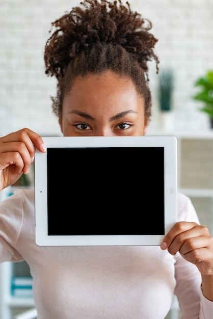 czarny pusty pusty ekran iPada w kobiecej dłoni, zerkający zza tabletu