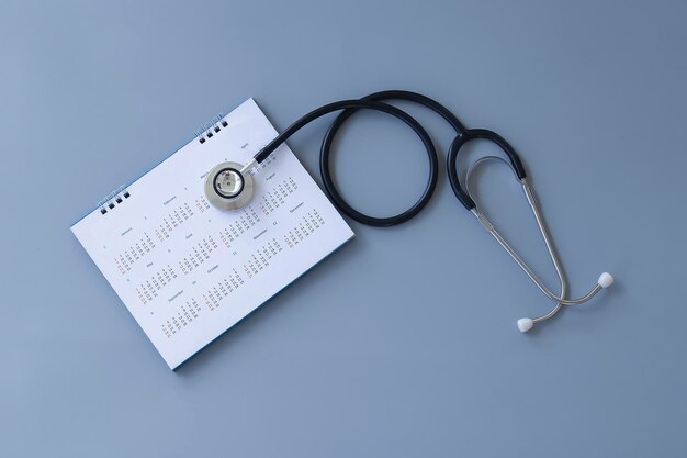 Czarny stetoskop i kalendarz na szarym tle koncepcja zdrowia
