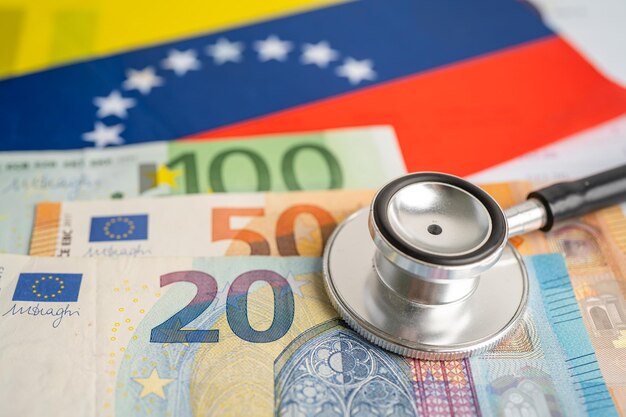Czarny stetoskop z banknotami euro na tle flagi Wenezueli Koncepcja biznesu i finansów