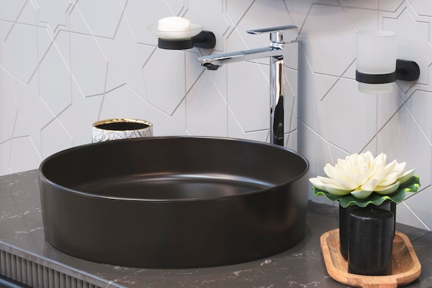Czarny umywalka z kranem w minimalistycznym nowoczesnym wnętrzu łazienki