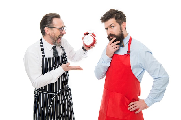 Czas na lunch Mężczyźni gotują z budzikiem Mężczyzna brodaty hipster i dojrzały fartuch szefa kuchni na białym tle Zacznij gotować już teraz Godziny pracy i przerwa na lunch Brak czasu Sprawdź, która jest godzina