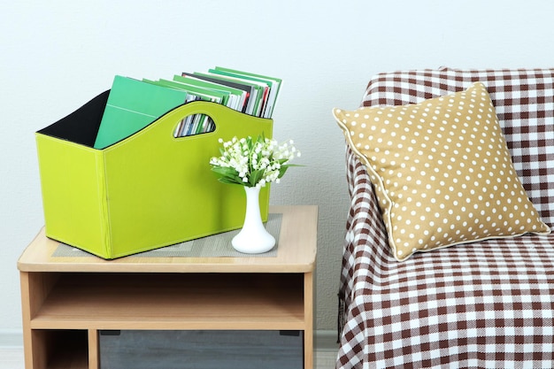 Czasopisma i foldery w zielonym pudełku na stoliku nocnym w pokoju