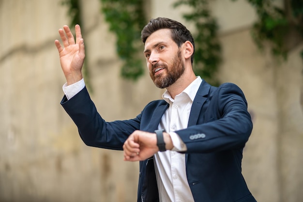 Czekanie. Młody biznesmen czeka na kogoś i wygląda na wyczekiwanego