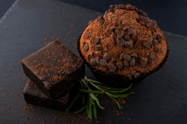 Czekoladowe babeczki i czekoladowe cukierki na czarnym stole czekoladowe babeczki Babeczki z czekoladą