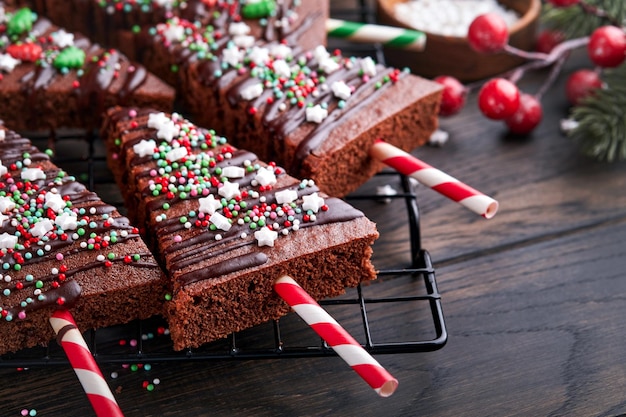 Czekoladowe ciasteczka Choinka z polewą czekoladową i świąteczną posypką na drewnianym stole Pomysły na świąteczne potrawy słodkie domowe świąteczne ciasto Koncepcja świątecznego gotowania Widok z góry