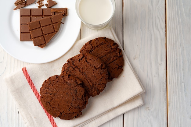 Czekoladowe ciasteczka i tabliczka czekolady na białej desce
