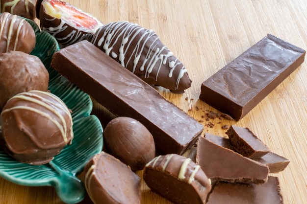 Zdjęcie czekoladowe tabliczki czekolady i trufle na drewnianym stole