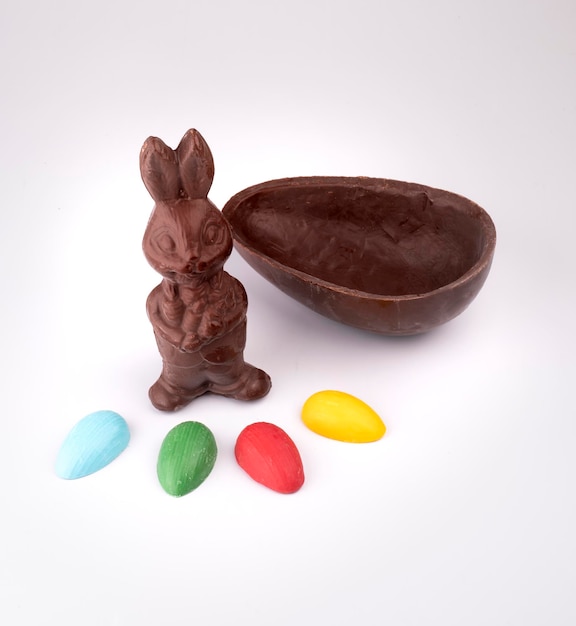 Czekoladowy króliczek wielkanocny domowe pół czekoladowe jajko i kolorowe jajka widziane z góry na białym tle