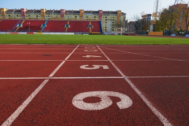 Czerwona bieżnia bieżnia lekkoatletyczna na stadionie z numeracją.