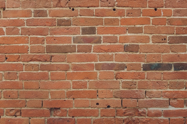 Czerwona cegła ściana tekstury grunge ściany z winietowanymi narożnikami, może służyć do projektowania wnętrz.