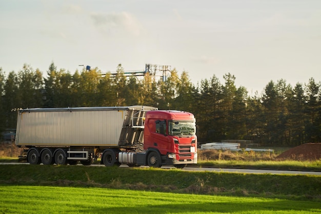 Czerwona ciężarówka przemysłowa w akcji na ruchliwej trasie transportowej