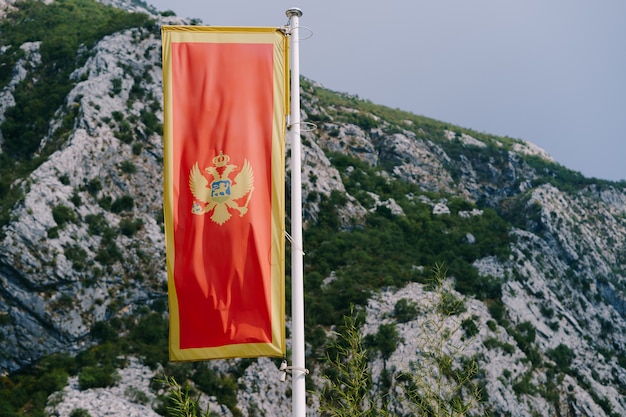 Czerwona flaga Czarnogóry z dwugłowym orłem na tle gór. Wysokiej jakości zdjęcie