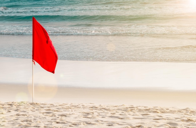 Czerwona flaga na plaży. Flaga ostrzegawcza burzy na plaży. Niebezpieczeństwo koncepcja tło.