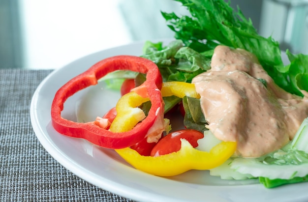 Czerwona i żółta papryka w sałatce warzywnej w białym talerzu na stole jadalnym koncepcja zdrowej żywności