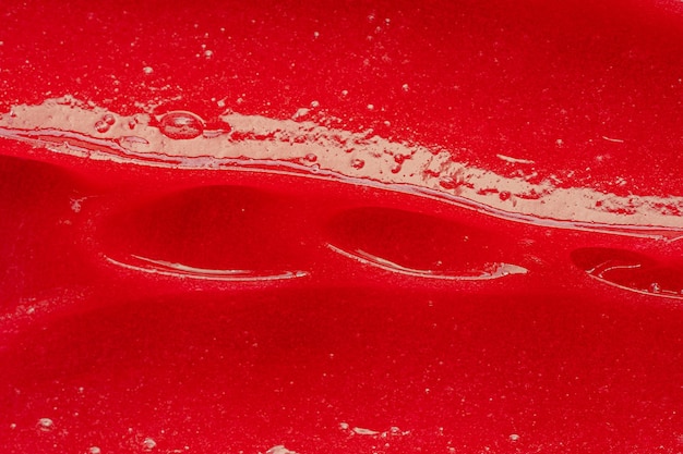 Czerwona konsystencja żelu Kosmetyczny przezroczysty płynny krem rozmazywanie próbki produktu do pielęgnacji skóry zbliżenie Pasta do zębów lub wosk