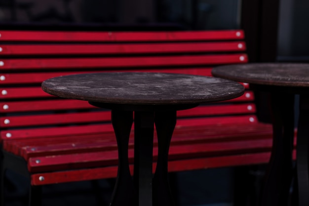 Czerwona ławka i stoły otwartej ulicznej kawiarni w mieście. podwórko domowe