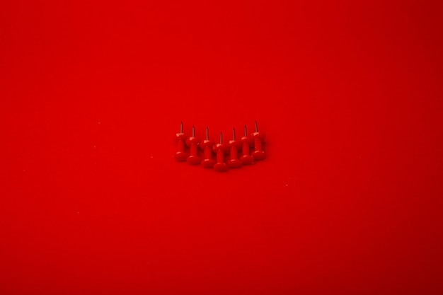Zdjęcie czerwona pinezka na monochromatycznym czerwonym tle