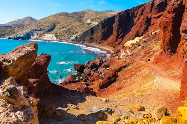 Zdjęcie czerwona plaża na wyspie santorini w grecji czerwone klify wulkaniczne i niebieskie morze piękny letni krajobraz w słoneczny dzień