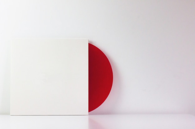 Zdjęcie czerwona płyta winylowa w białym pudełku z pustą przestrzenią do pisania.