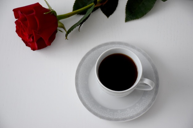 Czerwona Róża, Filiżanka Kawy Na Talerzu Szarej Herbaty Na Białym Stole. śniadanie Walentynkowe.