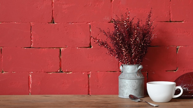 Zdjęcie czerwona ściana i kwiat z filiżanką kawy.