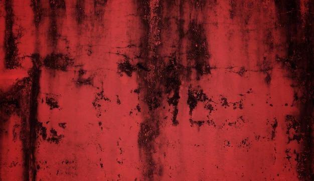 Czerwona ściana z czarno-białymi plamami i czarną plamą na dole.
