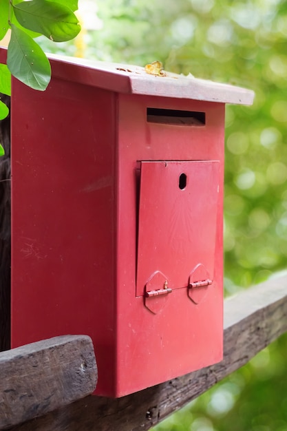 Zdjęcie czerwona skrzynka pocztowa z zielonym natury tłem