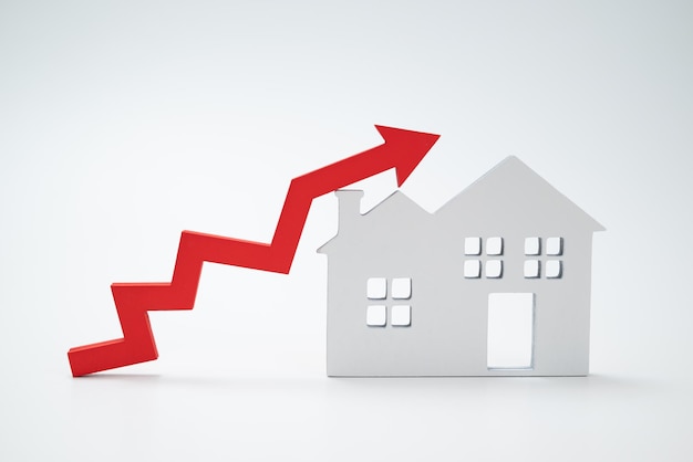 Czerwona strzałka w górę i dom Koncepcja rosnącej ceny nieruchomości