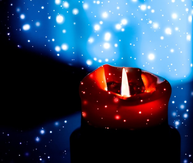 Zdjęcie czerwona świeca wakacyjna na ciemnym musującym tle śniegu luksusowy projekt marki na boże narodzenie sylwester i walentynki