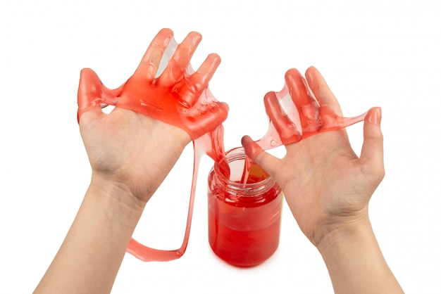 Czerwona szlamowa zabawka w rękach kobiety