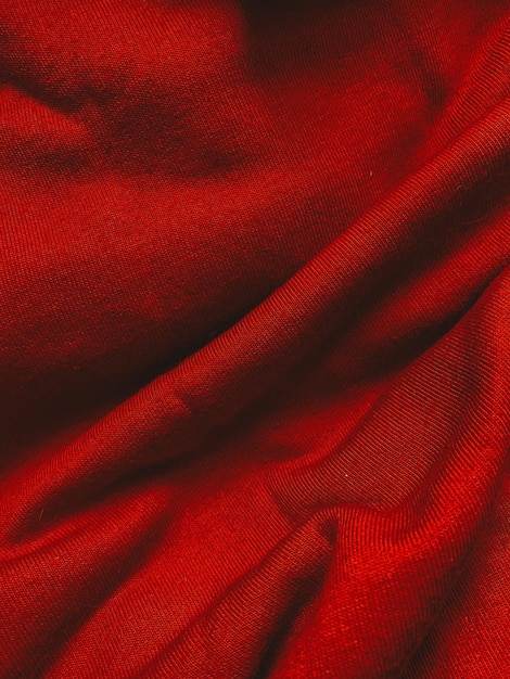 Czerwona tkanina z tkaniny tekstury tła z falistymi fałdami i cieniami zbliżenie