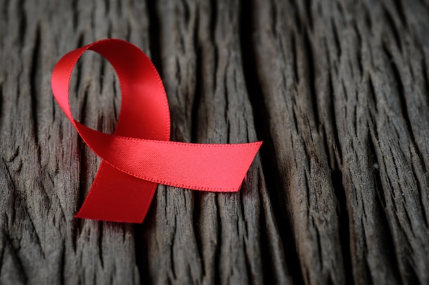 Zdjęcie czerwona wstążka na drewniane tło dla kampanii świadomości światowej aids day.