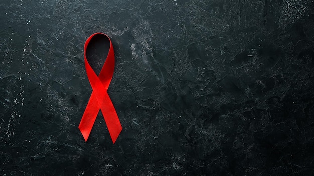 Czerwoną wstążką symbol Światowego Dnia Aids. Widok z góry. Wolne miejsce na kopię.