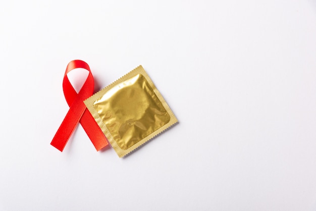 Czerwona Wstążka Z Kokardą Symbol Hiv, świadomości Raka Aids I Prezerwatywy Z Cieniami